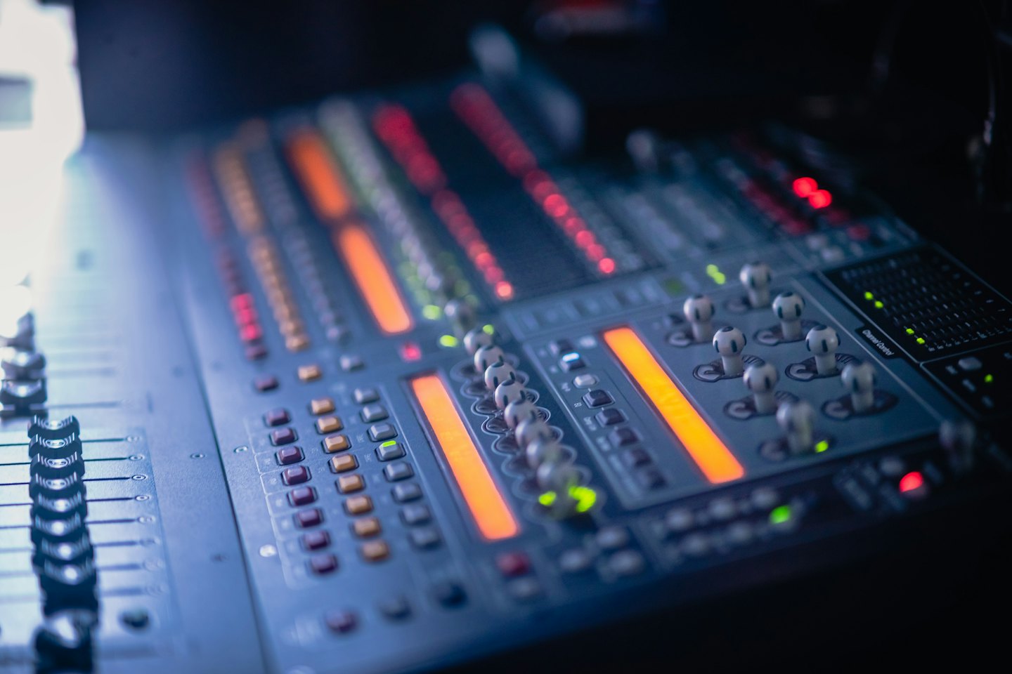 Professional audio mixing console with glowing buttons and faders.