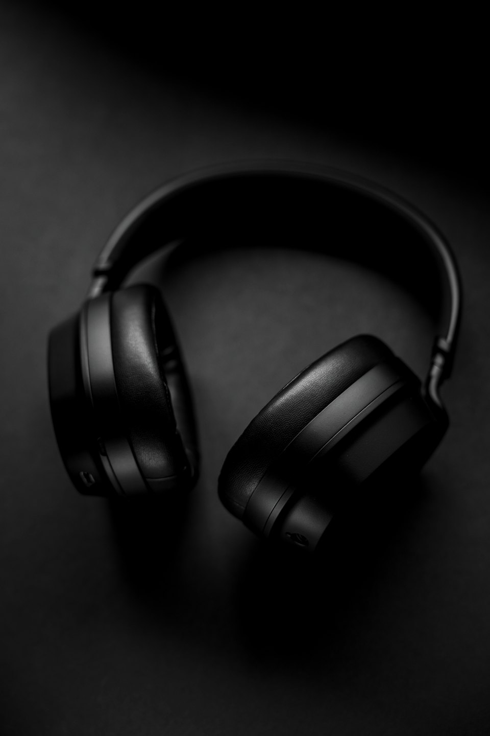 Black over-ear headphones on a dark surface.